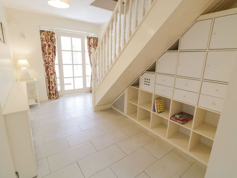 A hallway with stairs, drawer unit and lamp at Craiglea Lodge in Coleraine