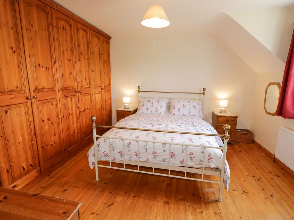 A bedroom with a bed and wardrobe at Craiglea Lodge in Coleraine