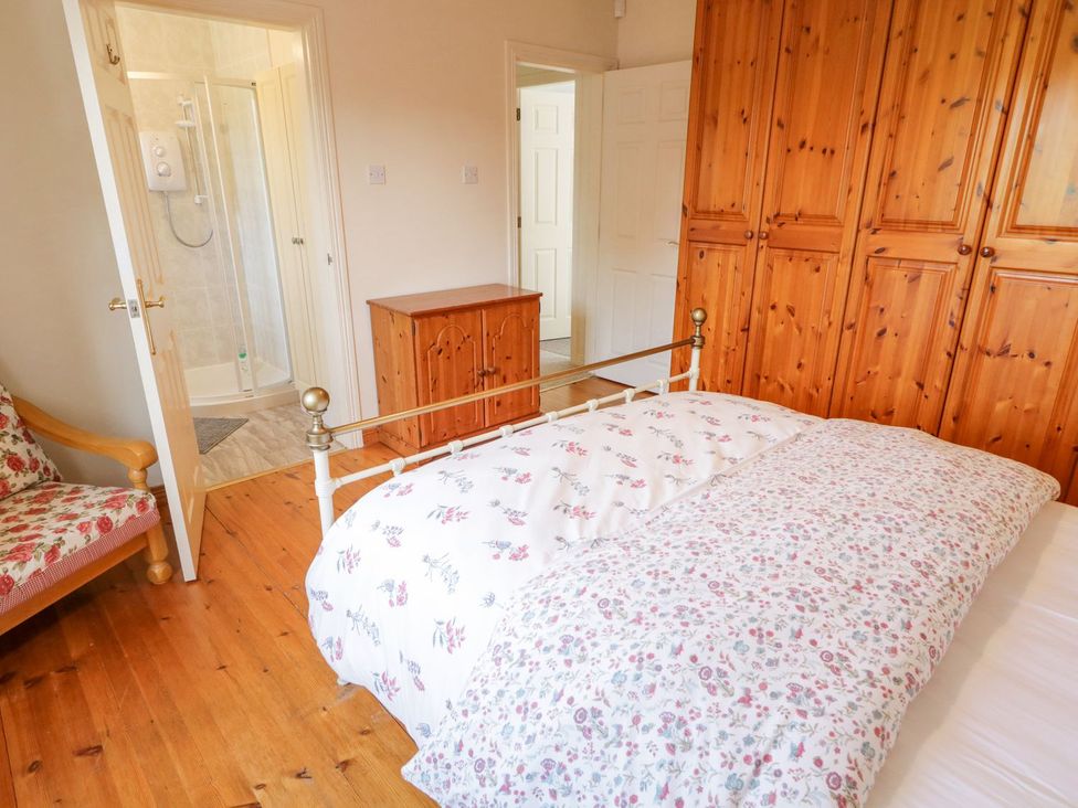 A bedroom with a bed and wardrobe at Craiglea Lodge in Coleraine