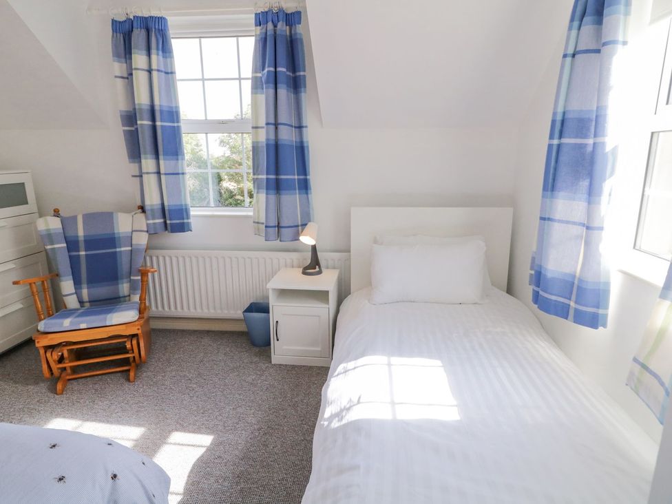 A bedroom with a single bed and rocking chair at Craiglea Lodge in Coleraine
