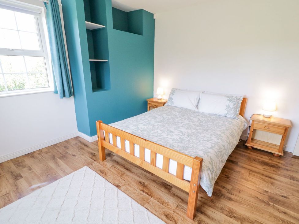 A bedroom with a bed and nightstands at Craiglea Lodge in Coleraine
