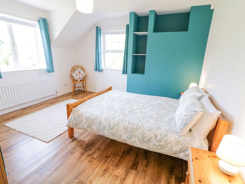 A bedroom with a bed and chair at Craiglea Lodge in Coleraine