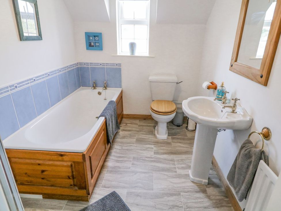 A bathroom with a bathtub, toilet, and sink at Craiglea Lodge in Coleraine