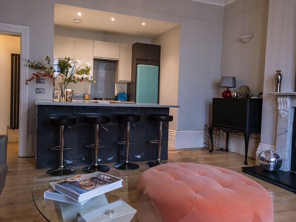 A kitchen with bar stools and a refrigerator at Gorgeous 2Bed Apartment with Patio in Brighton And Hove