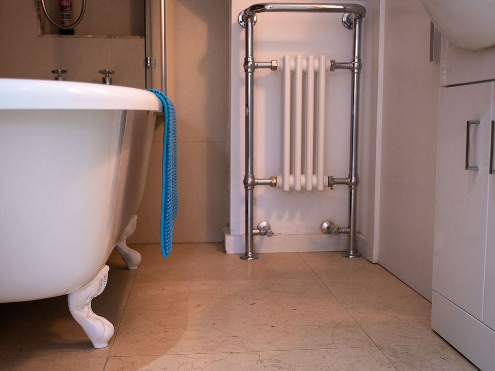 A bathroom with a bathtub, radiator, and towel at Gorgeous 2Bed Apartment with Patio in Brighton And Hove