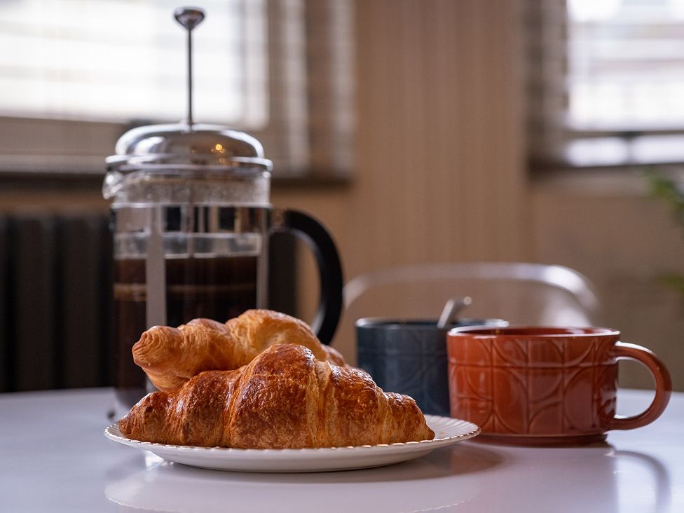 A kitchen table with coffee and croissants at Gorgeous 2Bed Apartment with Patio in Brighton And Hove