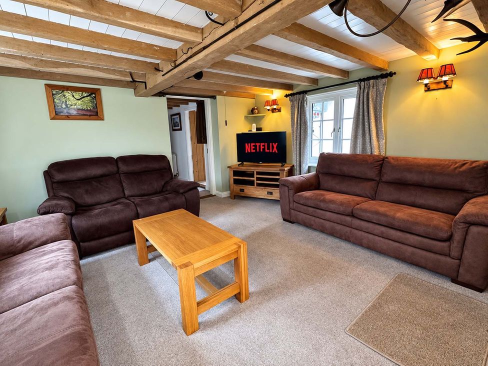 A living room with two sofas, a coffee table and a television at Holdfast Cottage Sleeps 12 in The New Forest, Bramshaw near Totton, Hampshire