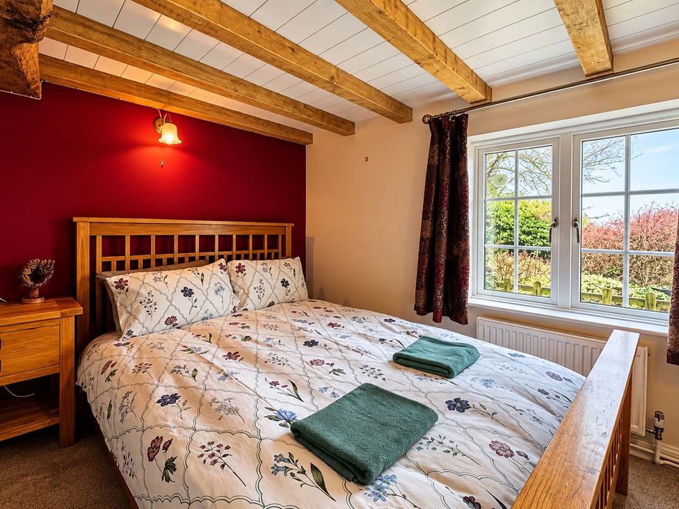 A bedroom with a bed and bedside table at Holdfast Cottage Sleeps 12 in The New Forest, Bramshaw near Totton, Hampshire
