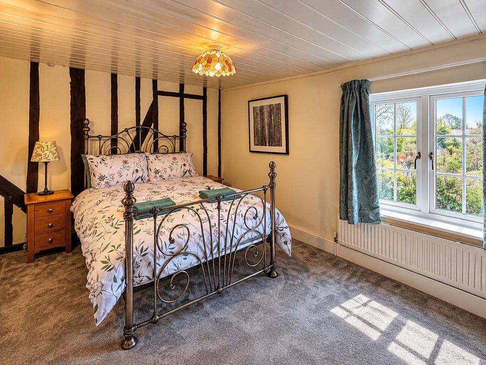 A bedroom with a bed and bedside table at Holdfast Cottage Sleeps 12 in The New Forest, Bramshaw near Totton, Hampshire