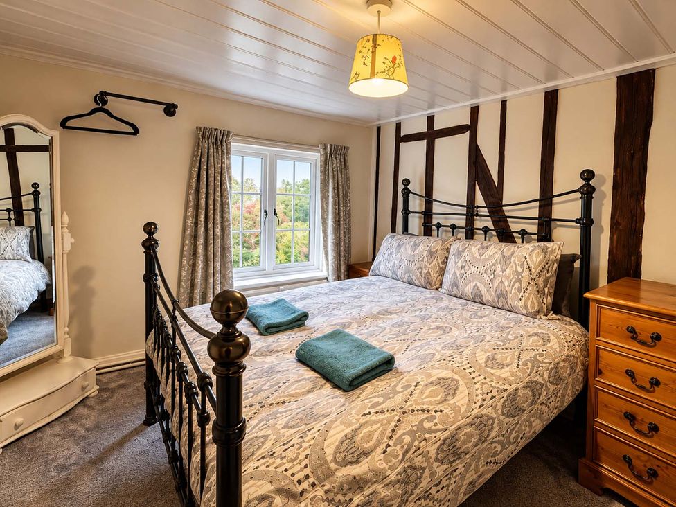 A bedroom with a bed and a mirror at Holdfast Cottage Sleeps 12 in The New Forest, Bramshaw near Totton, Hampshire