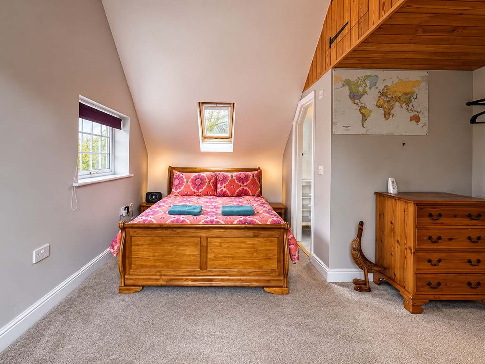 A bedroom with a bed and dresser at Holdfast Cottage Sleeps 12 in The New Forest, Bramshaw near Totton, Hampshire