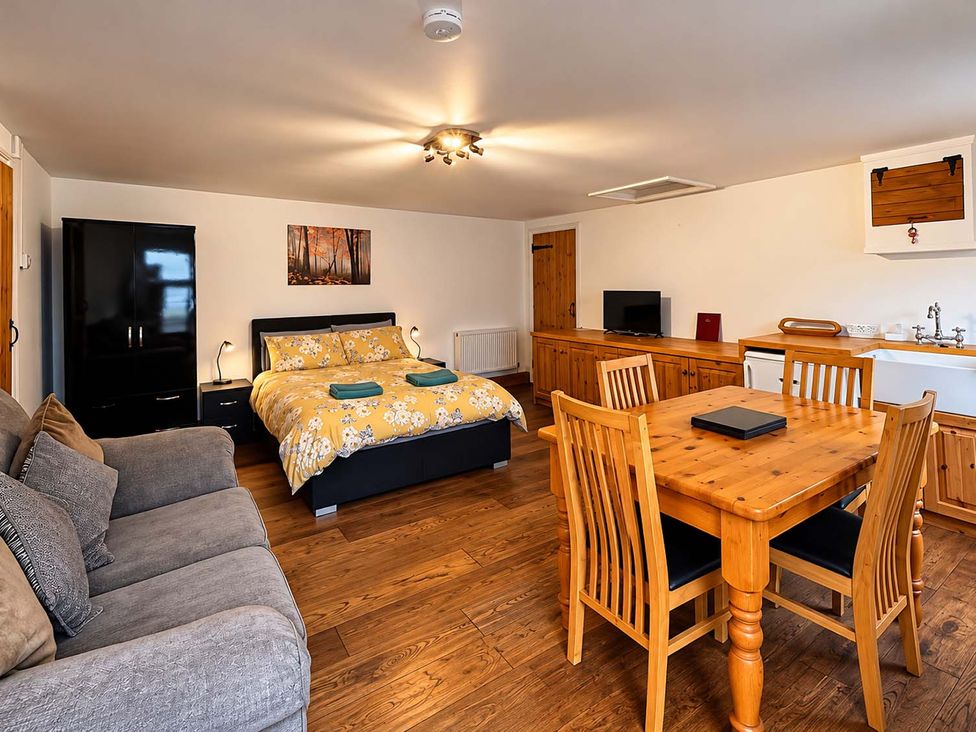 A studio with a bed and dining area at Holdfast Cottage Sleeps 12 in The New Forest Bramshaw near Totton, Hampshire