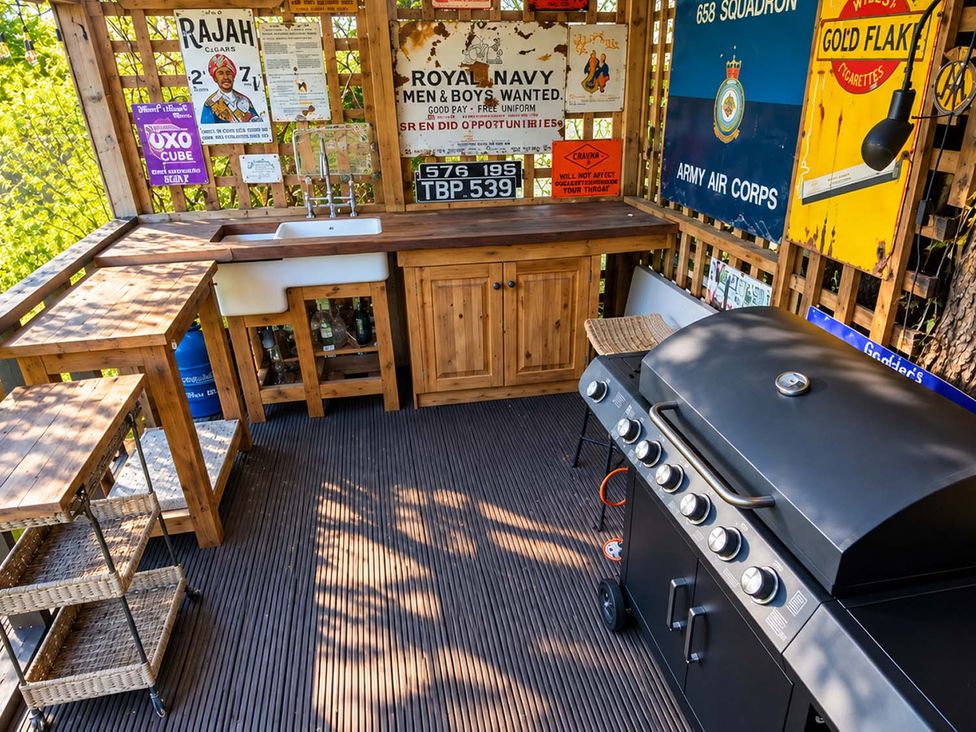 An outdoor cooking area with a grill and wooden countertop at Holdfast Cottage Sleeps 12 in The New Forest, Bramshaw near Totton, Hampshire