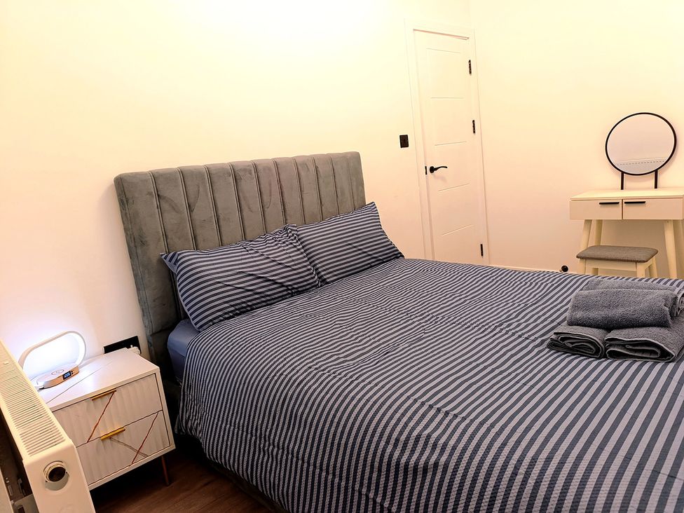 A bedroom with a bed and bedside table at Cardiff Cozy One Bedroom Apartment in Cardiff