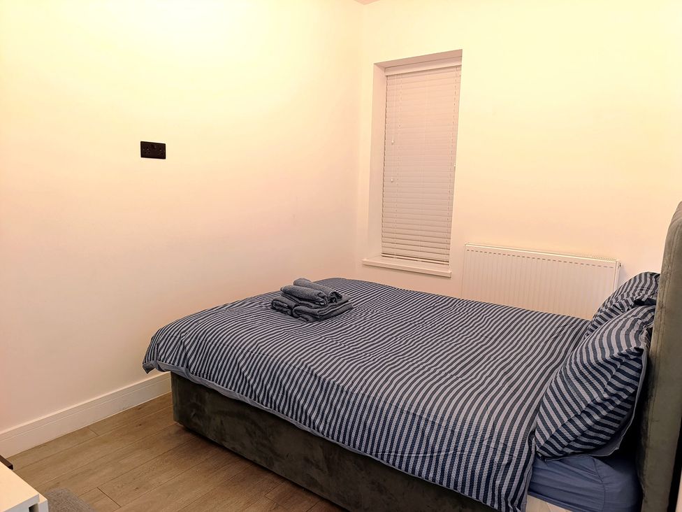A bedroom with a bed, linens, and a window at Cardiff Cozy One Bedroom Apartment in Cardiff