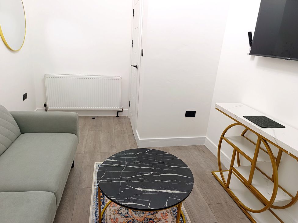 A living room with a sofa and coffee table at Cardiff Cozy One Bedroom Apartment in Cardiff