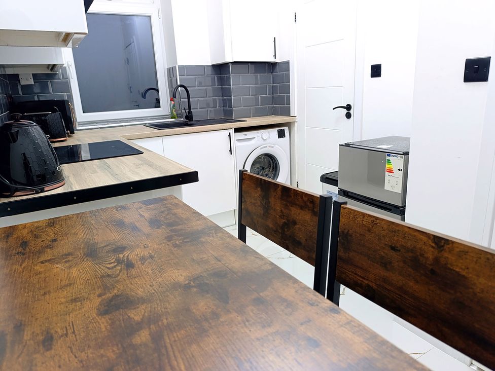 A kitchen with appliances and dining table at Cardiff Cozy One Bedroom Apartment in Cardiff