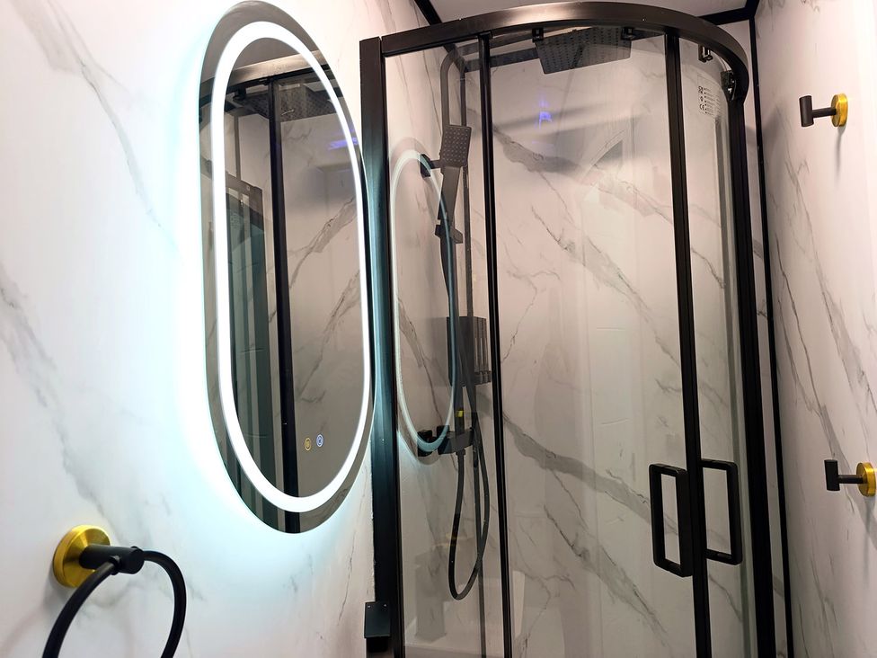 A bathroom with a shower and a mirror at Cardiff Cozy One Bedroom Apartment in Cardiff
