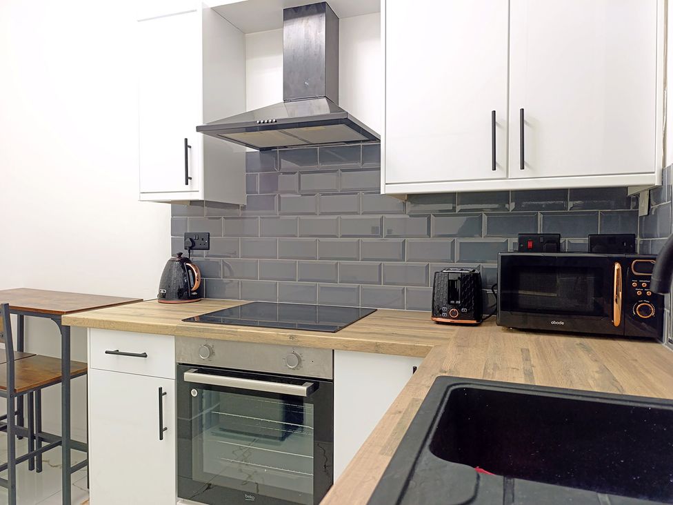 A kitchen with stove and microwave at Cardiff Cozy One Bedroom Apartment in Cardiff