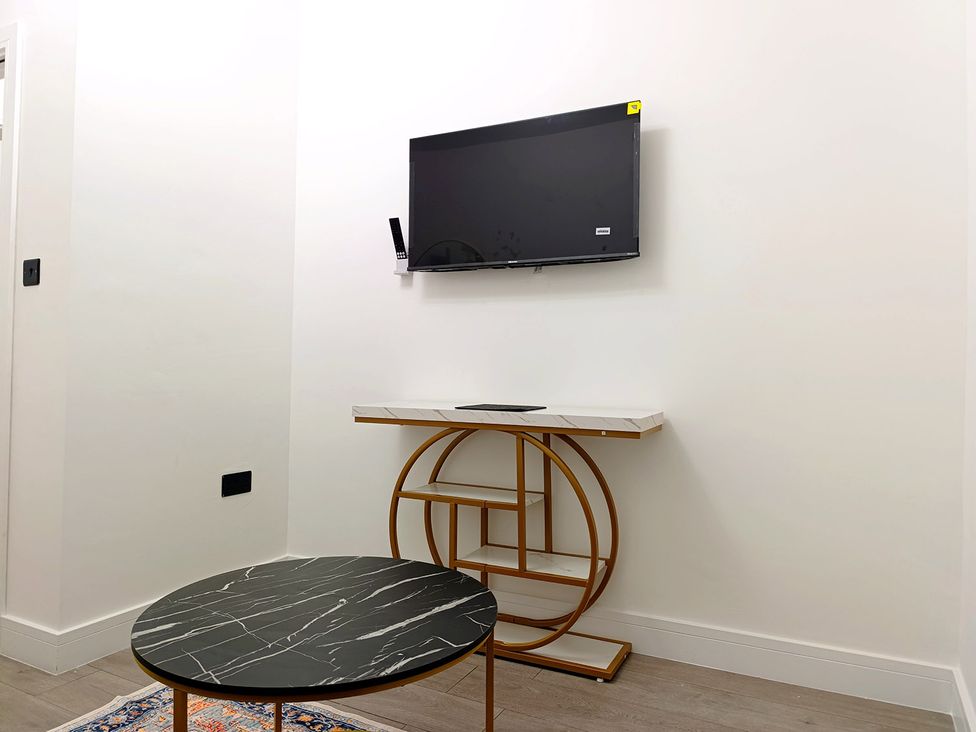 A living room with a television and a coffee table at Cardiff Cozy One Bedroom Apartment in Cardiff