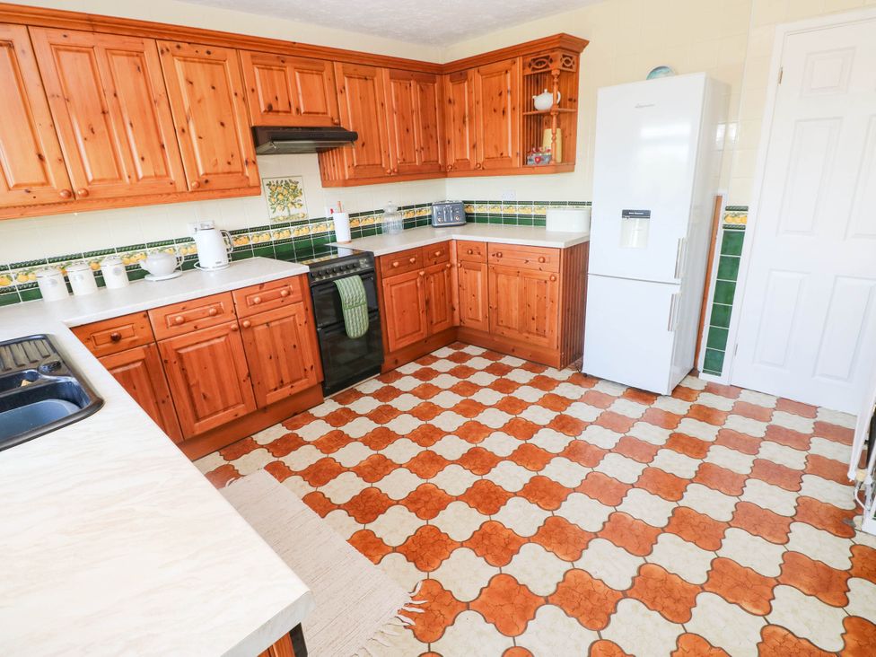 A kitchen with wooden cabinets and a refrigerator at 24 Little Castle Grove Hubberston