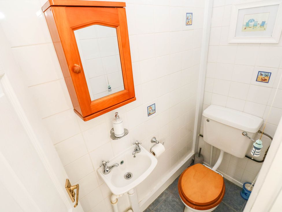 A bathroom with a sink, toilet and mirror at 24 Little Castle Grove, Hubberston