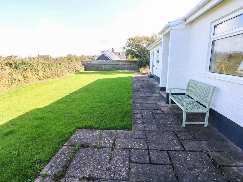 A garden with a bench and patio area at 24 Little Castle Grove Hubberston