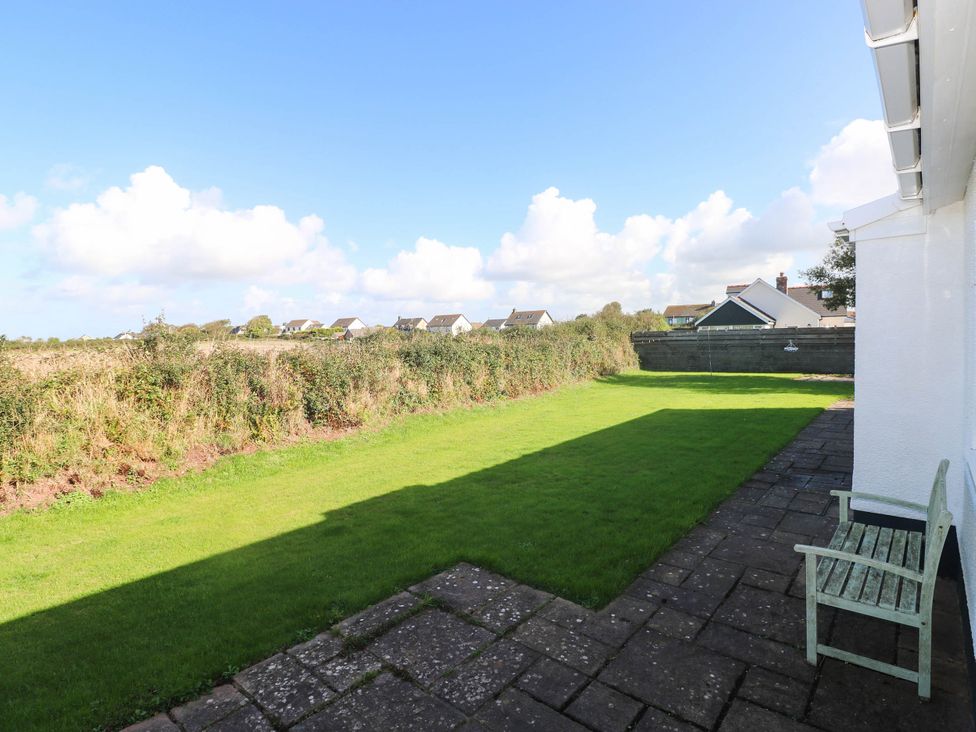 A garden with grass and a patio area at 24 Little Castle Grove Hubberston