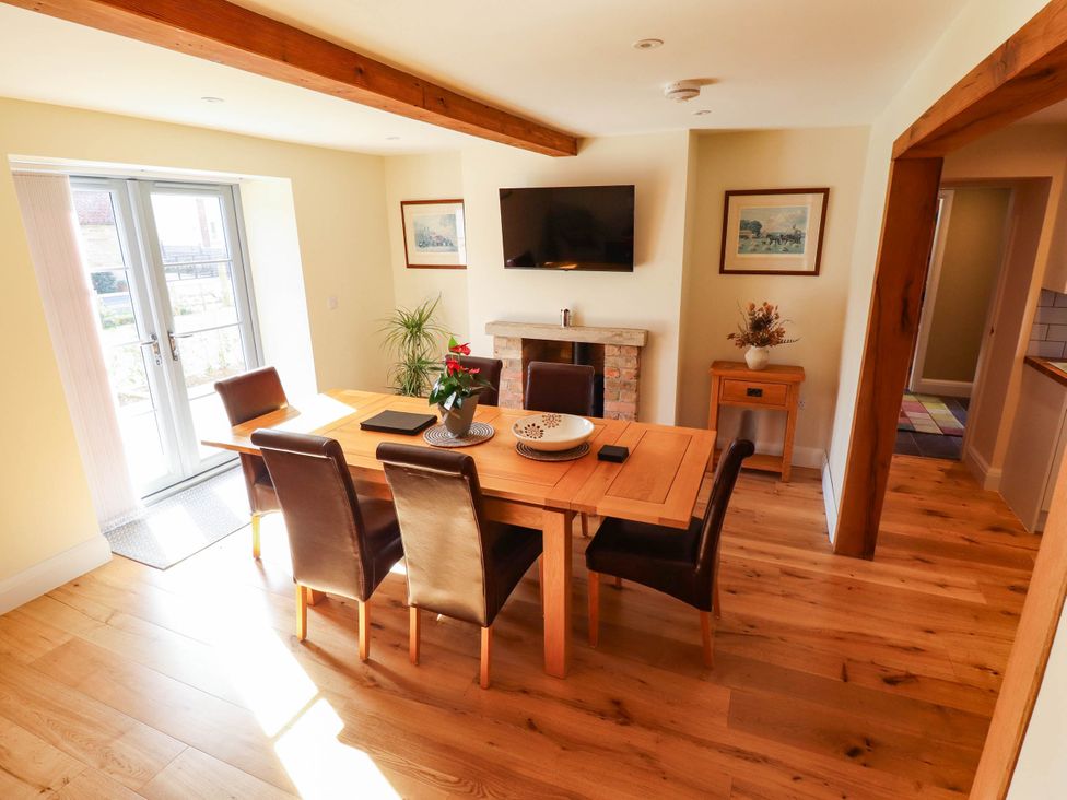 A dining room with a table and chairs at Three Chimneys in Scampton near Ingham