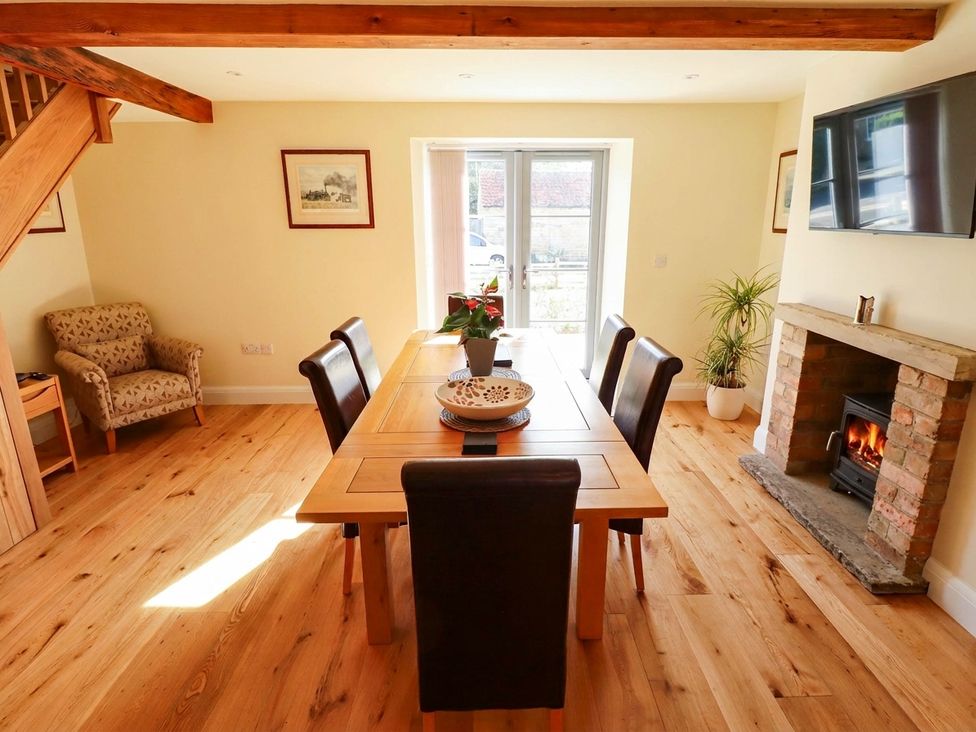 A dining room with a table and chairs at Three Chimneys in Scampton near Ingham