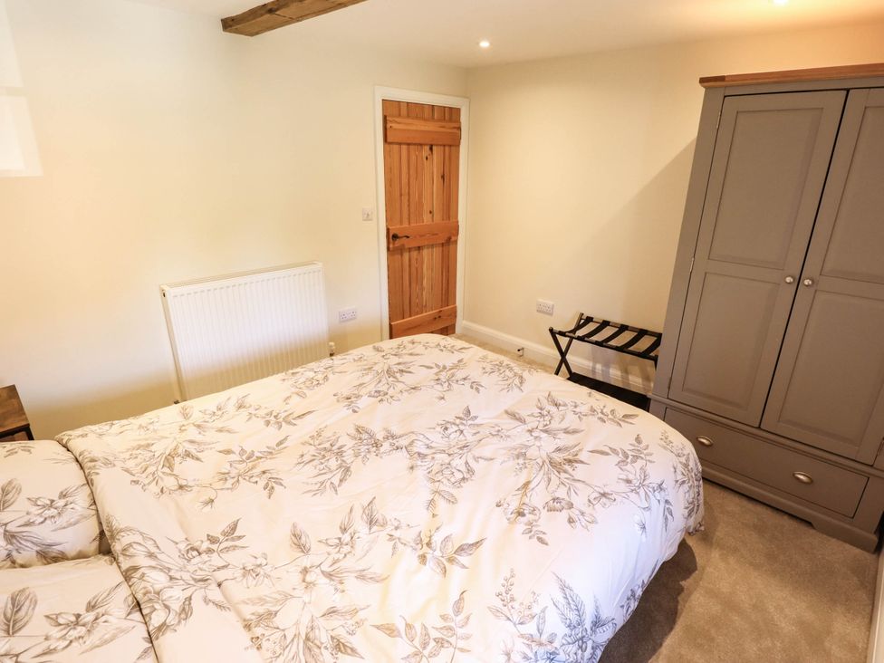 A bedroom with a bed and wardrobe at Three Chimneys in Scampton near Ingham