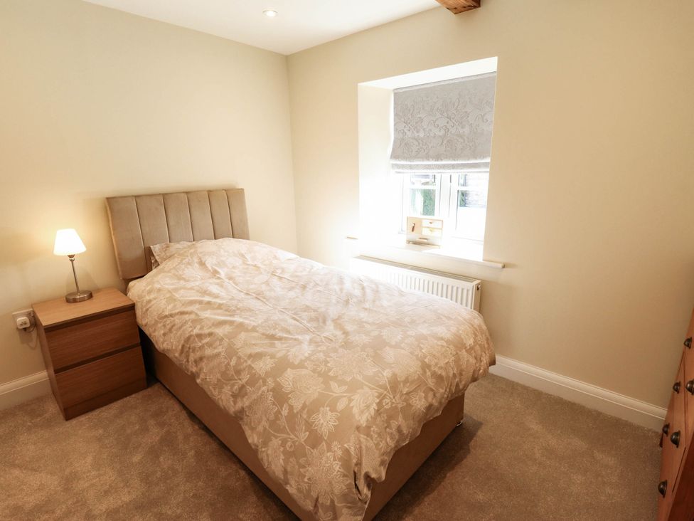 A bedroom with a bed and bedside table at Three Chimneys in Scampton near Ingham
