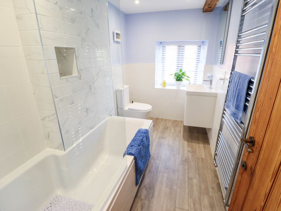 A bathroom with a bathtub and sink at Three Chimneys in Scampton near Ingham