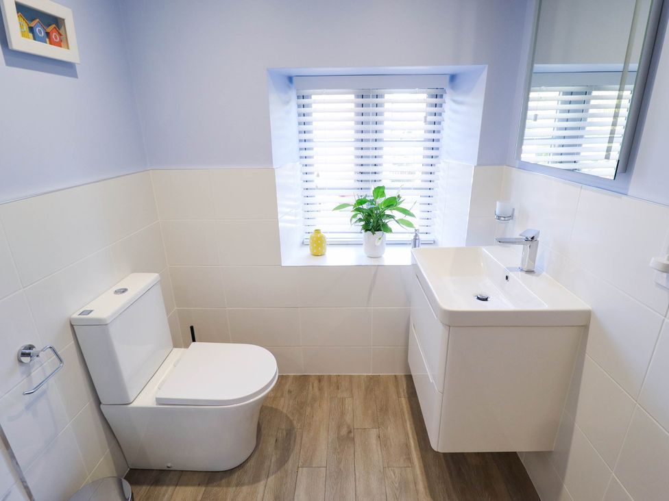 A bathroom with a toilet, sink, and plant at Three Chimneys in Scampton near Ingham