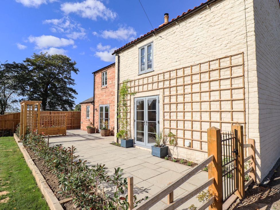 An outdoor area with a house and garden features at Three Chimneys Scampton near Ingham