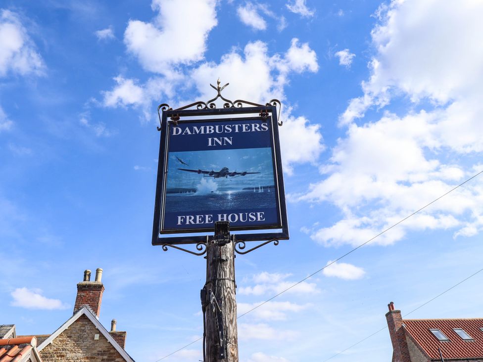 A sign for Dambusters Inn with an aircraft image in the background at Dambusters Inn in Scampton near Ingham