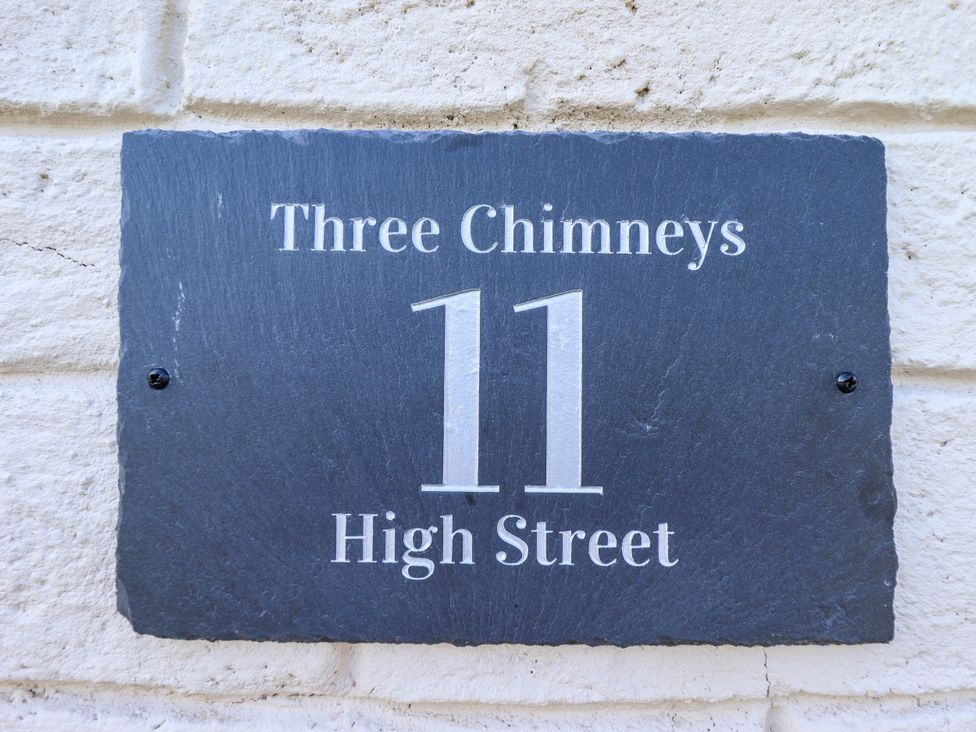 A house sign displaying Three Chimneys and 11 High Street
