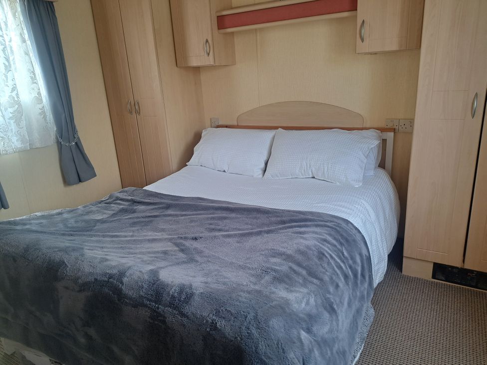 A bedroom with a bed and wardrobe at Chapel Farm Holiday Park No 6 Bunnies View Appleby-in-Westmorland