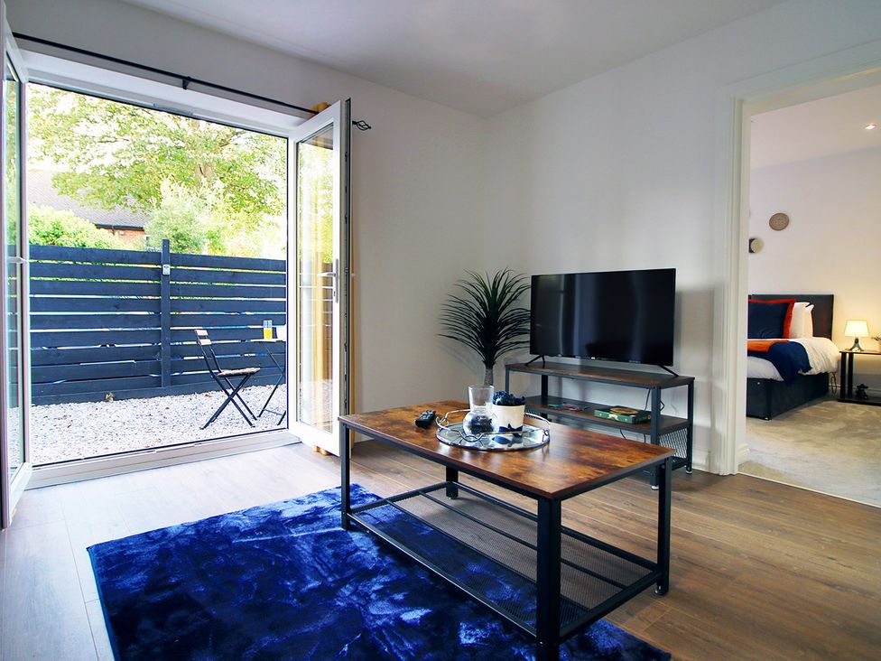 A living room with a coffee table and television at 2 bed Cardiff city centre apartment in Cardiff