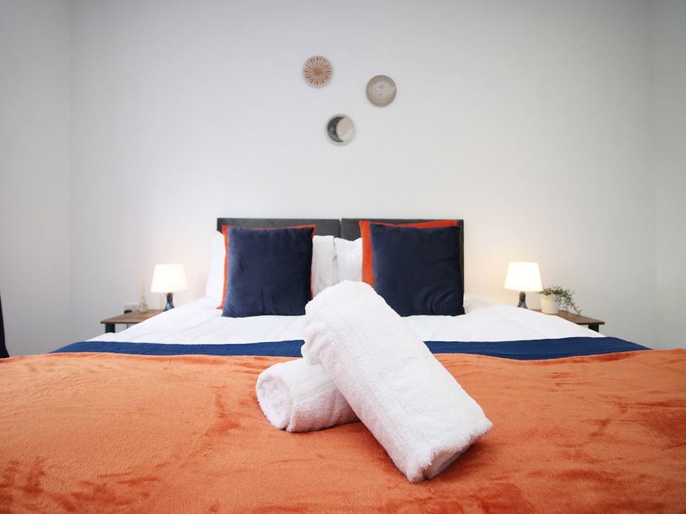 A bedroom with a bed and towels at 2 bed Cardiff city centre apartment Cardiff