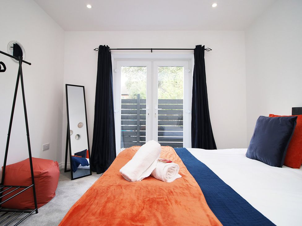 A bedroom with a bed and mirror at 2 bed Cardiff city centre apartment in Cardiff