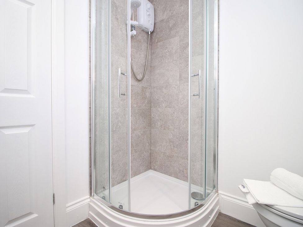 A shower enclosure with a toilet and towels at 2 bed Cardiff city centre apartment in Cardiff