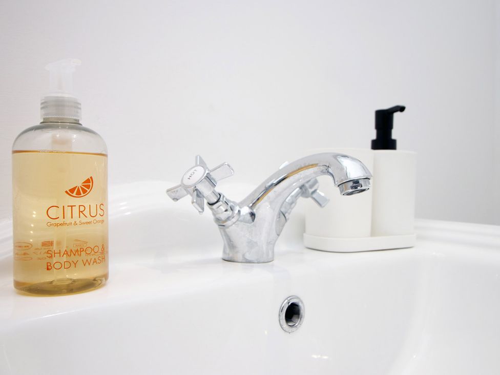 A sink with a faucet and shampoo bottle at 2 bed Cardiff city centre apartment Cardiff