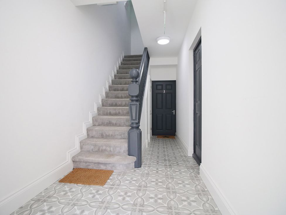 A hallway with a staircase and doors at 2 bed Cardiff city centre apartment in Cardiff