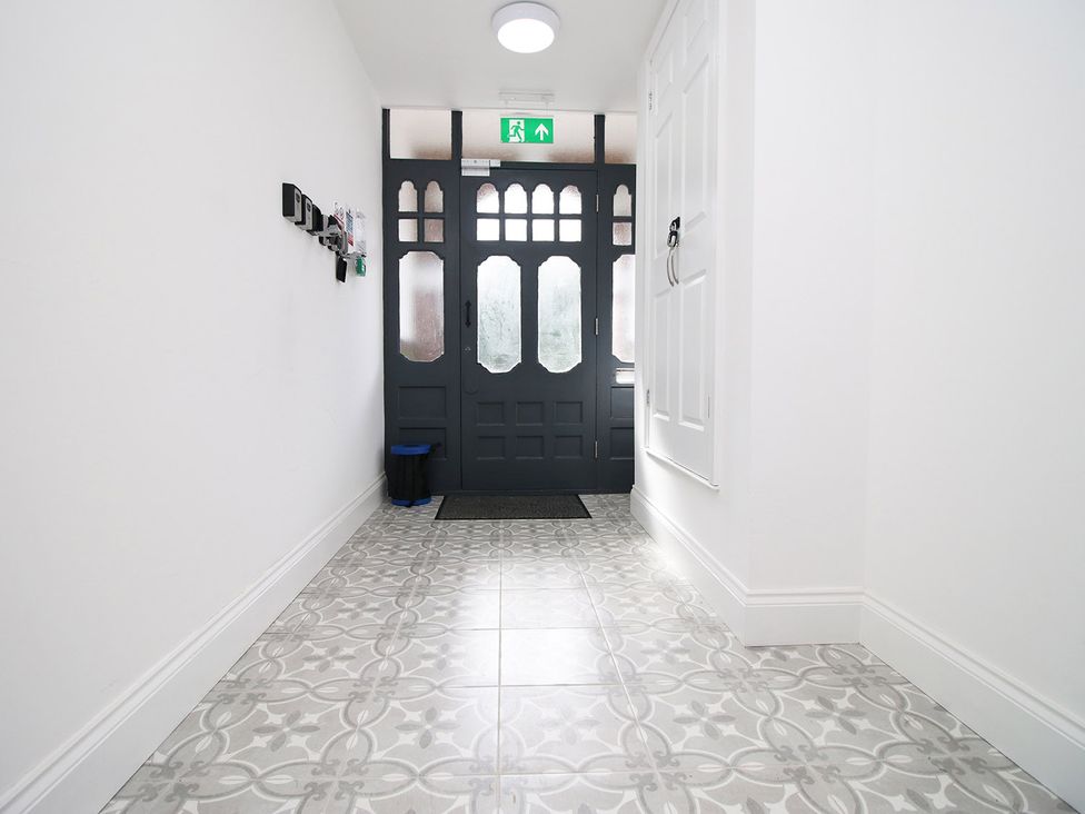 A hallway with a door and mat at 2 bed Cardiff city centre apartment in Cardiff