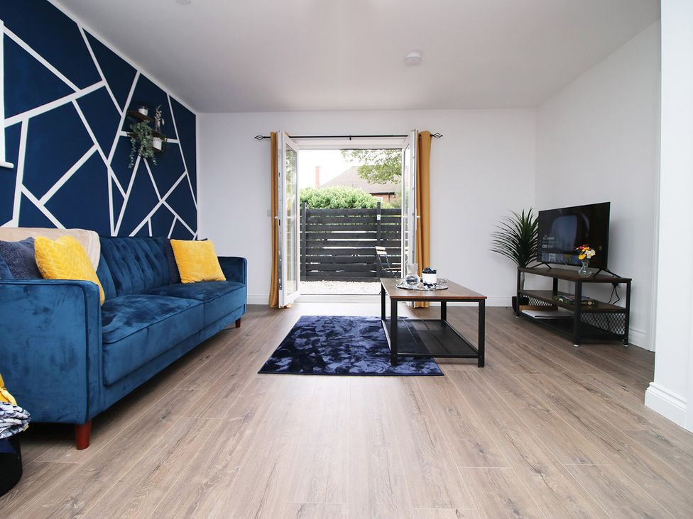 A living room with a sofa, table, and TV at 2 bed Cardiff city centre apartment Cardiff
