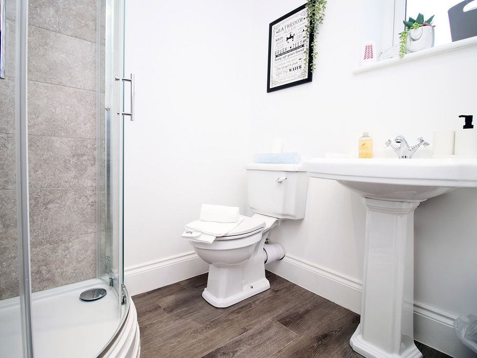A bathroom with a shower, toilet, sink, and towels at 2 bed Cardiff city centre apartment, Cardiff