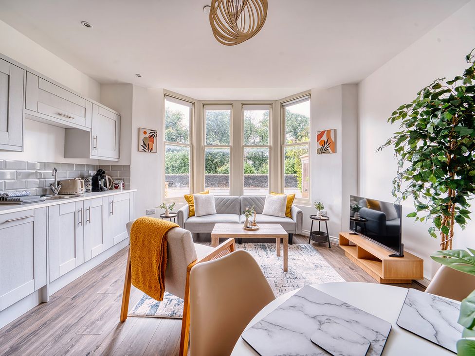 A living room with a kitchen, sofa, and dining area at Stunning 2 Bed by the City Centre and Bute Park, Cardiff