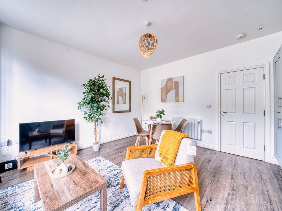 A living room with a television, chairs and a dining table at Stunning 2 Bed by the City Centre and Bute Park, Cardiff