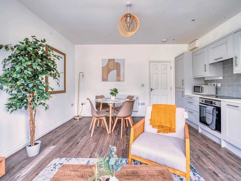 A living room with a sofa chair and dining table at Stunning 2 Bed by the City Centre and Bute Park, Cardiff
